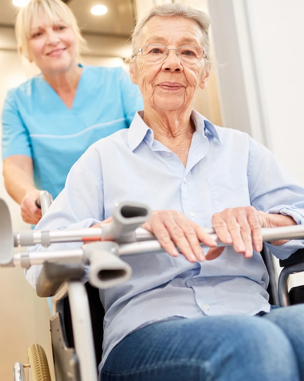 Senior patient being assisted with a wheelchair and crutches during a home visit