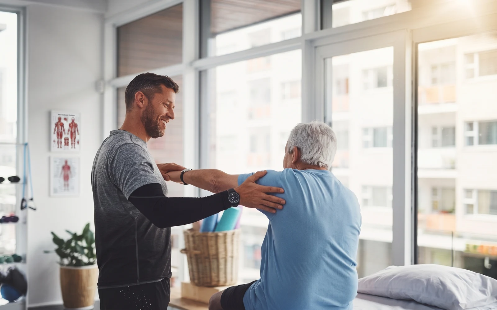 Therapist helping a senior patient with a shoulder stretch during a home visit