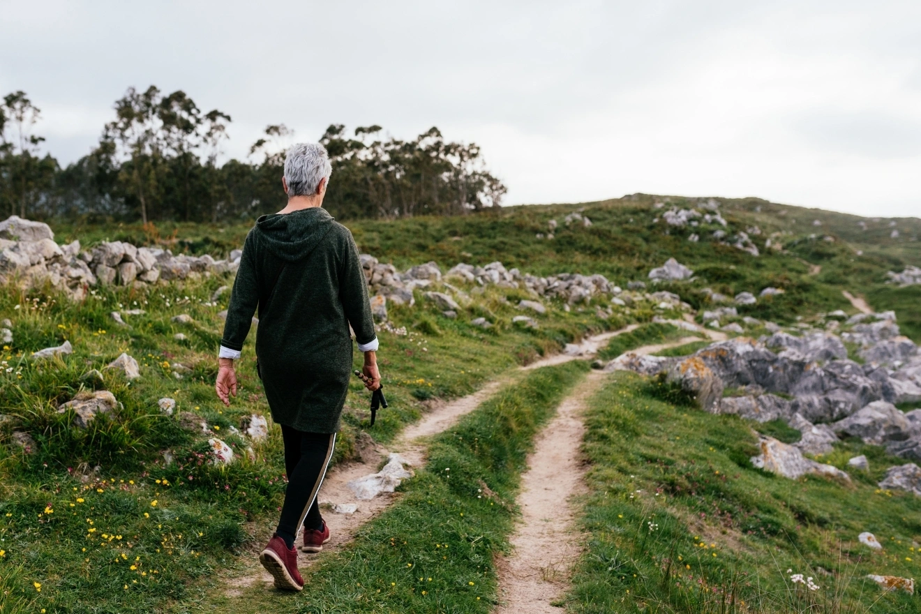 older woman outdoor hiking uneven slope